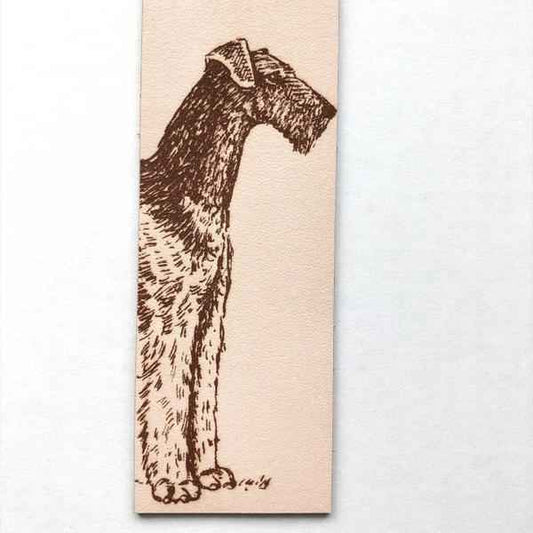 The leather bookmark with the antique art of an airedale terrier dog engraved on it.