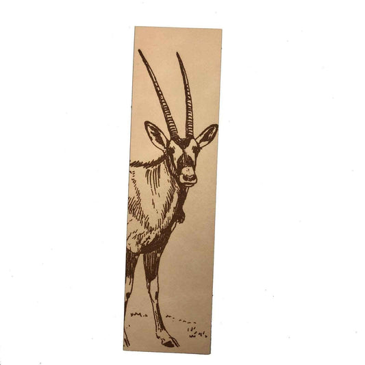 A leather bookmark engraved with the art of an antelope on it.
