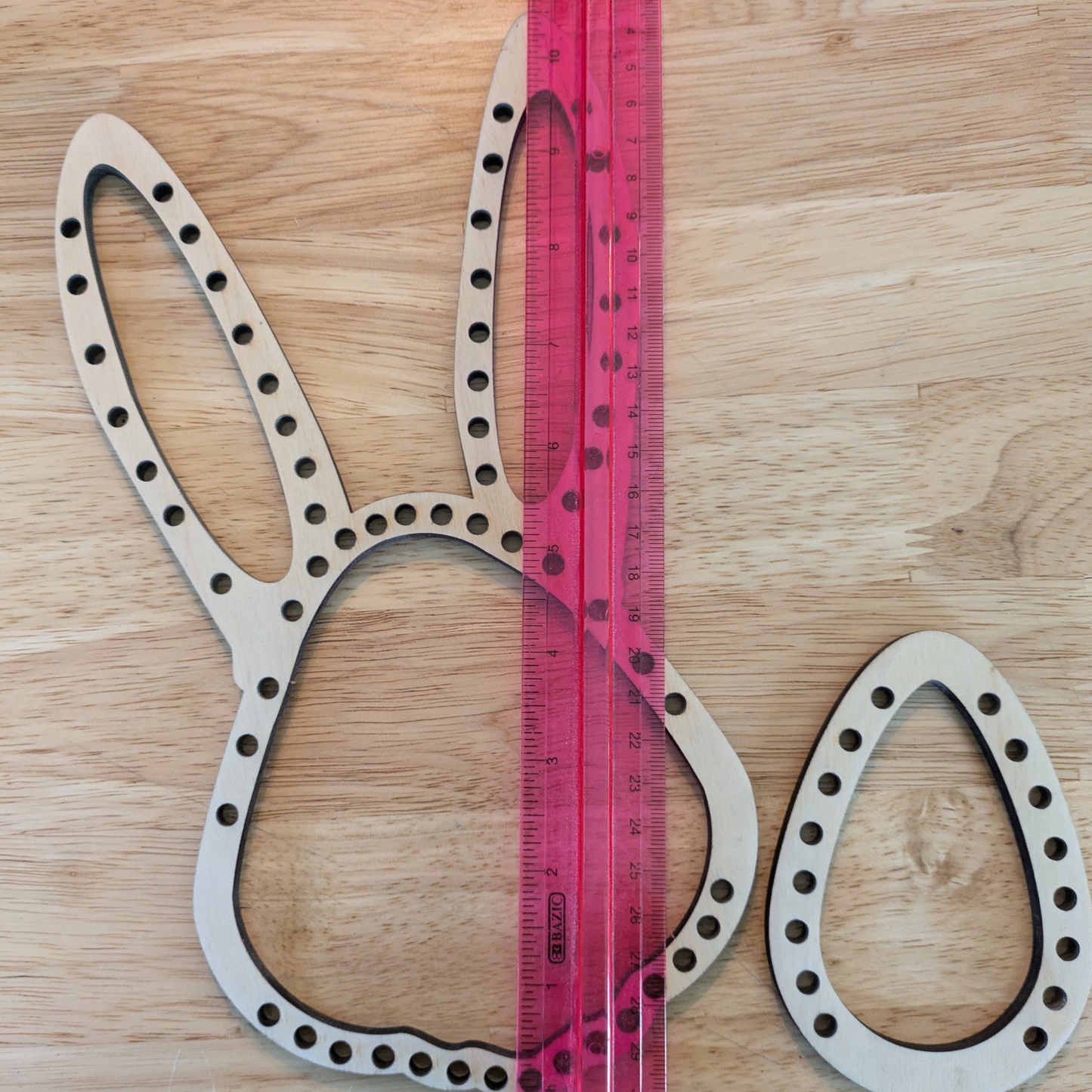 Thea Easter themed rabbit and egg looms next to a ruler for scale.
