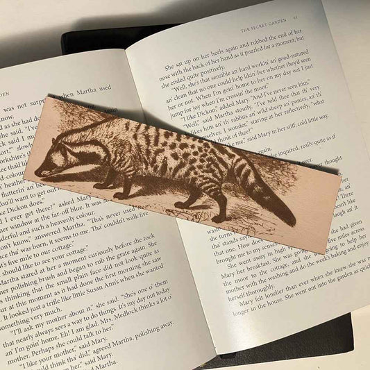 A leather bookmark engraved with the antique art of a civet on it.