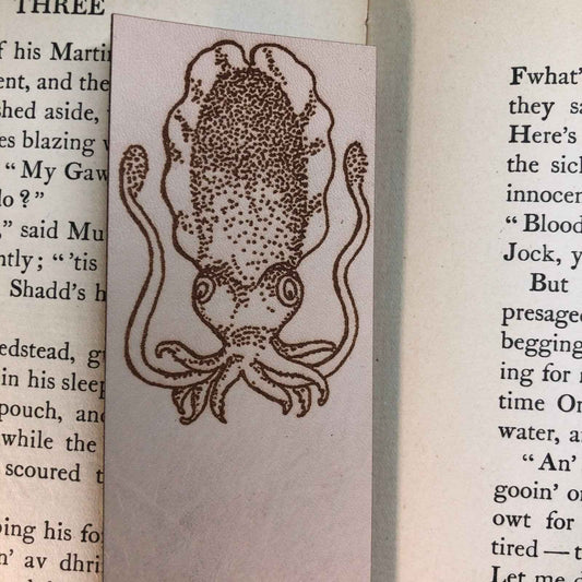 A leather bookmark engraved with the antique art of a cuttlefish.