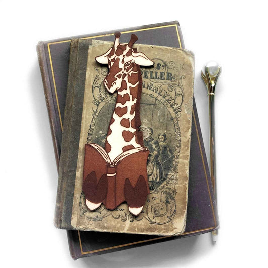 A leather bookmark shaped like a giraffee reading a book. Great Book lover gift.