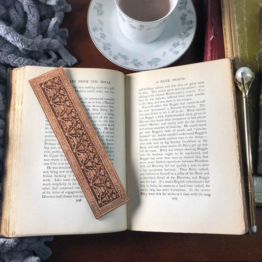 A leather bookmark engraved with the antique decorative art that is either Greek or Roman.