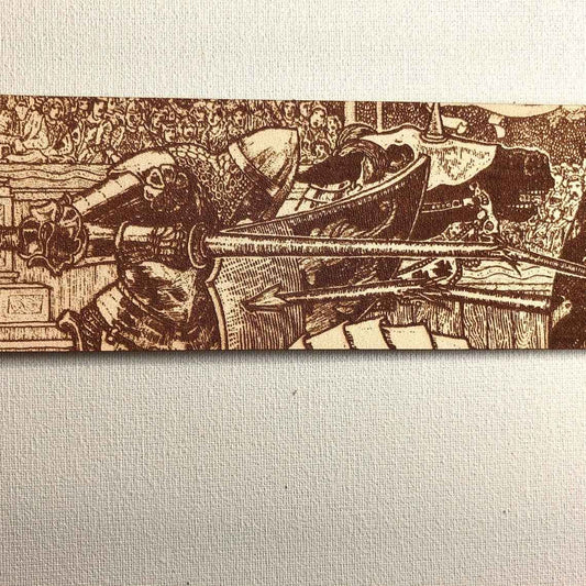 A leather bookmark engraved with the antique art of knights jousting.