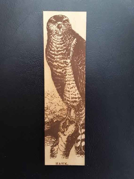 A leather bookmark engraved with the antique art of a hawk.