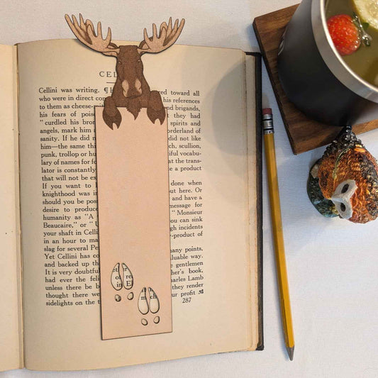 A photograph of exclusive personalizable moose leather bookmark resting on the pages of an open book.