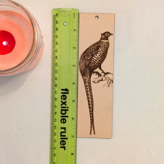 The pheasant bird bookmark next to a ruler for scale.