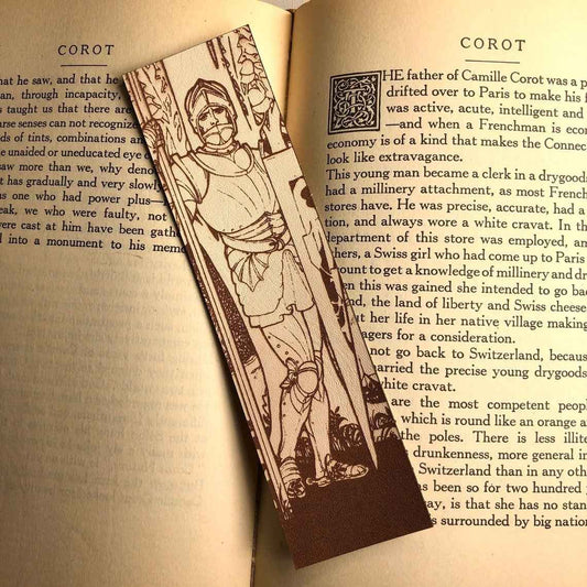 A leather bookmark with the antique art of a knight wearing plate armor engraved on it.