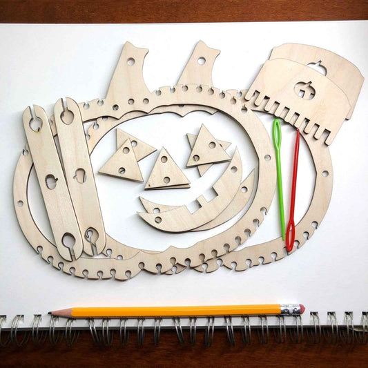 A picture of our fun Halloween themed look it, including pumpkin looms, jack-o-latern pieces, yarn and a shuttle.