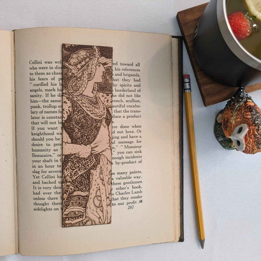 A leather bookmark with the antique art of a beautiful princess in a tower on it.