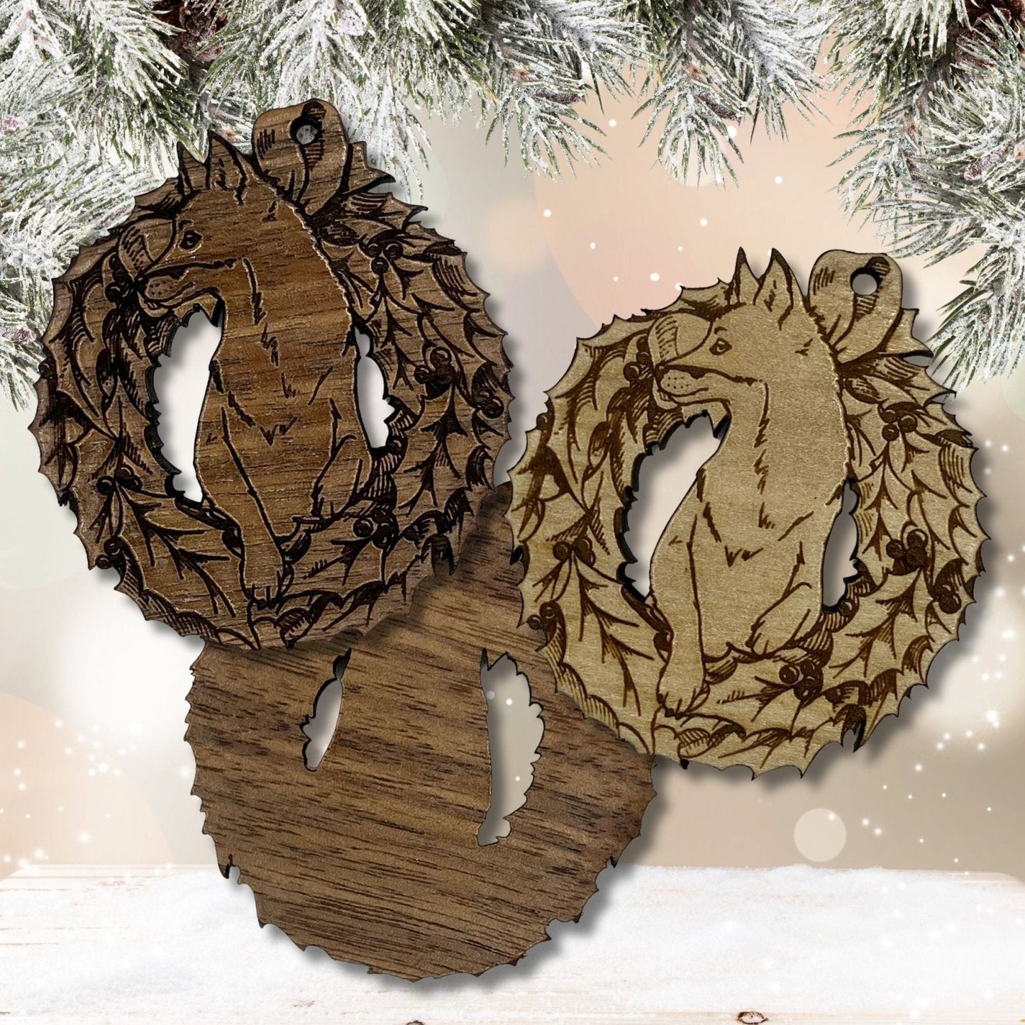 Shows the dark and light wooden fox ornaments. The dark ornament is to the left and the light fox ornament is to the right. Under these ornaments is the back of the dark ornament showing it is not engraved. Wood Fox Ornaments Ornament Raven King Crafts