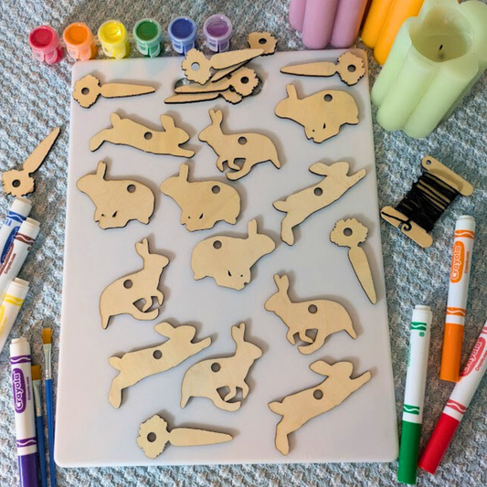 A wood Easter or Spring themed ornament blank kit with rabbits and carrots.