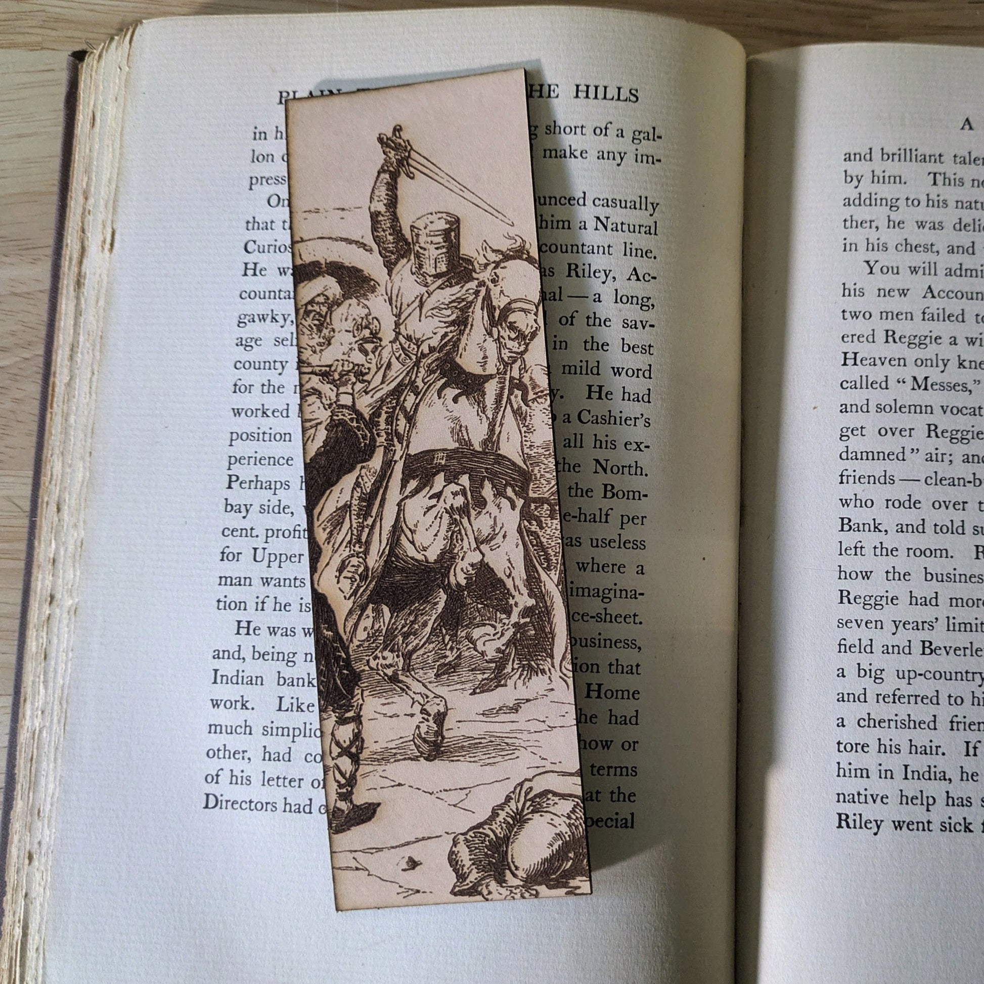 A leather bookmark with the art of a knight on horseback engraved on it. 