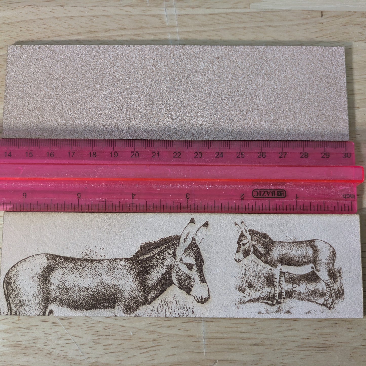 The leather donkey bookmark by a ruler. 