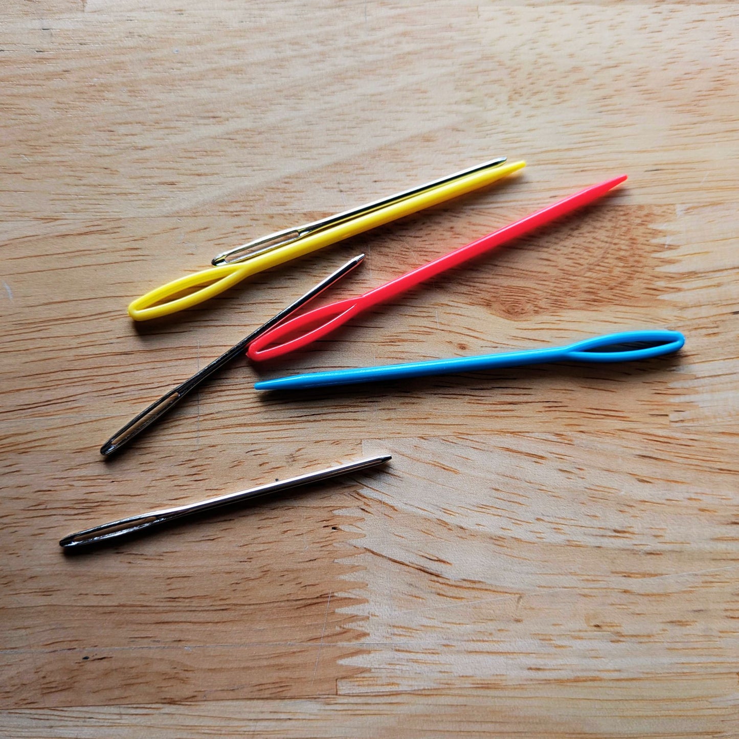 Photograph shows the plastic needles next to the metal ones. The plastic needles colors vary.