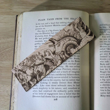A leather bookmark engraved with the antique art of the battle of Ragnarok on it.