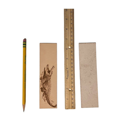 A photograph of the front of the leather bookmark and the back. The bookmarks are next to a ruler and a pencil for scale. Back photo shows the bookmark back is unfinished. Alligator Bookmark - Leather Bookmarks Raven King Crafts