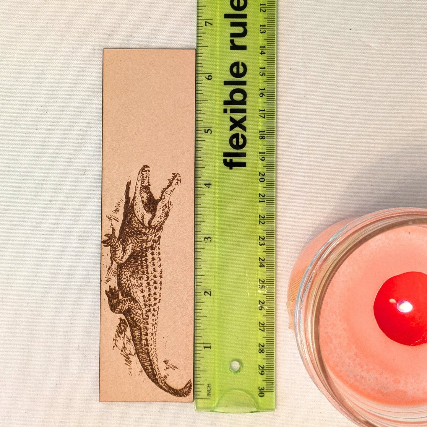 A photograph of historical alligator leather bookmark next to a ruler for scale. Alligator Bookmark - Leather Bookmarks Raven King Crafts
