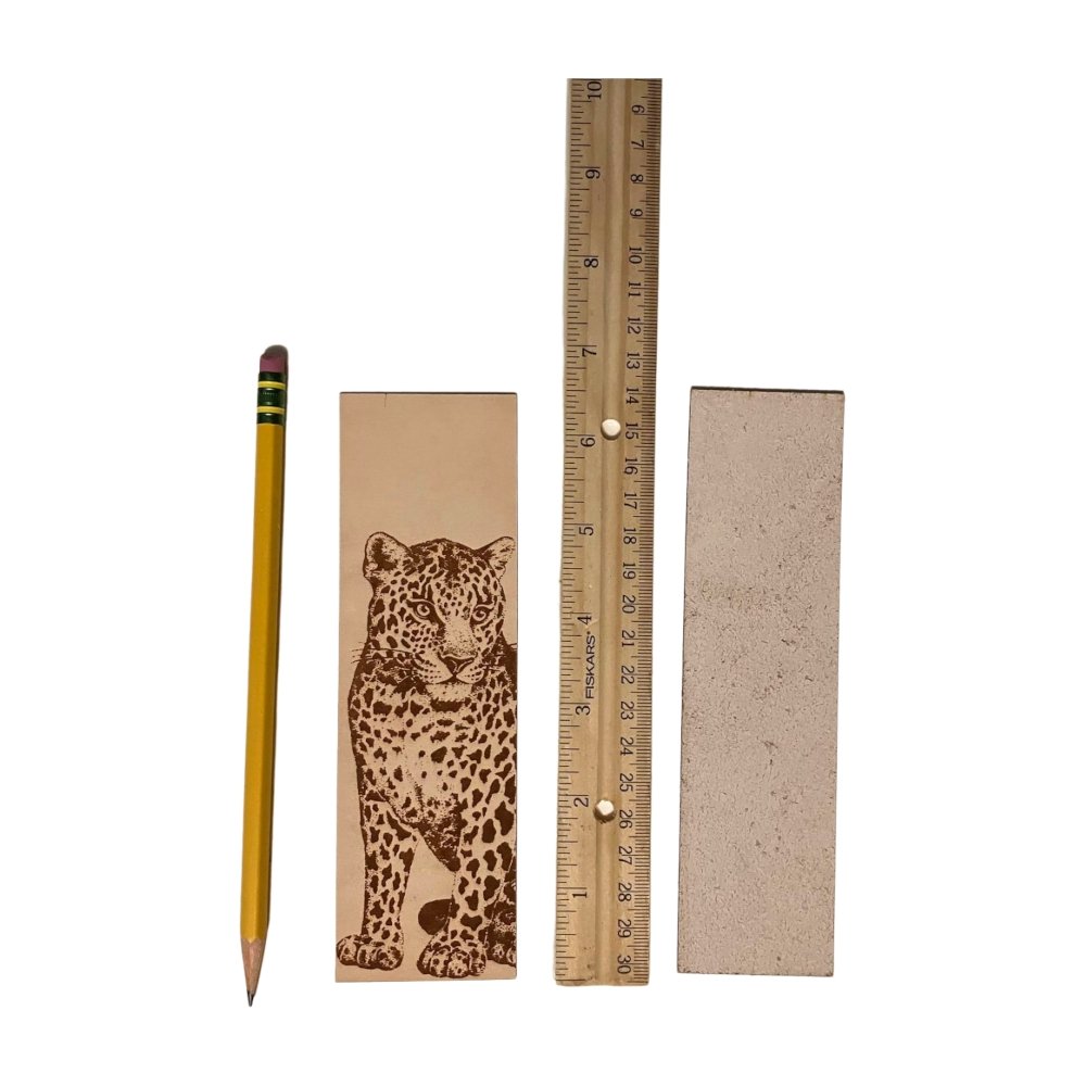 A photograph of the front of the leather bookmark and the back. The bookmarks are next to a ruler and a pencil for scale. Back photo shows the bookmark back is unfinished.