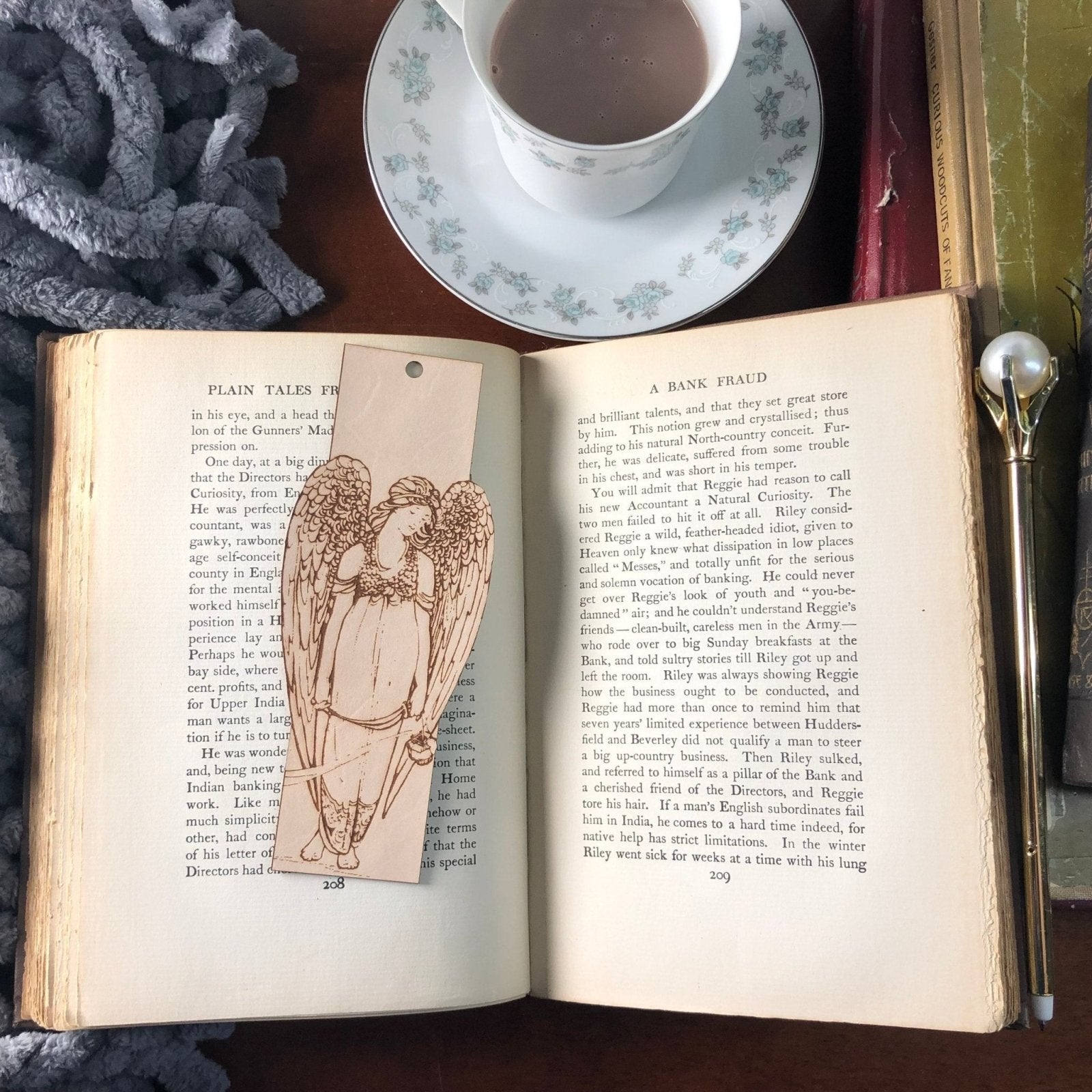 The leather angel bookmark resting on the pages of an open book.