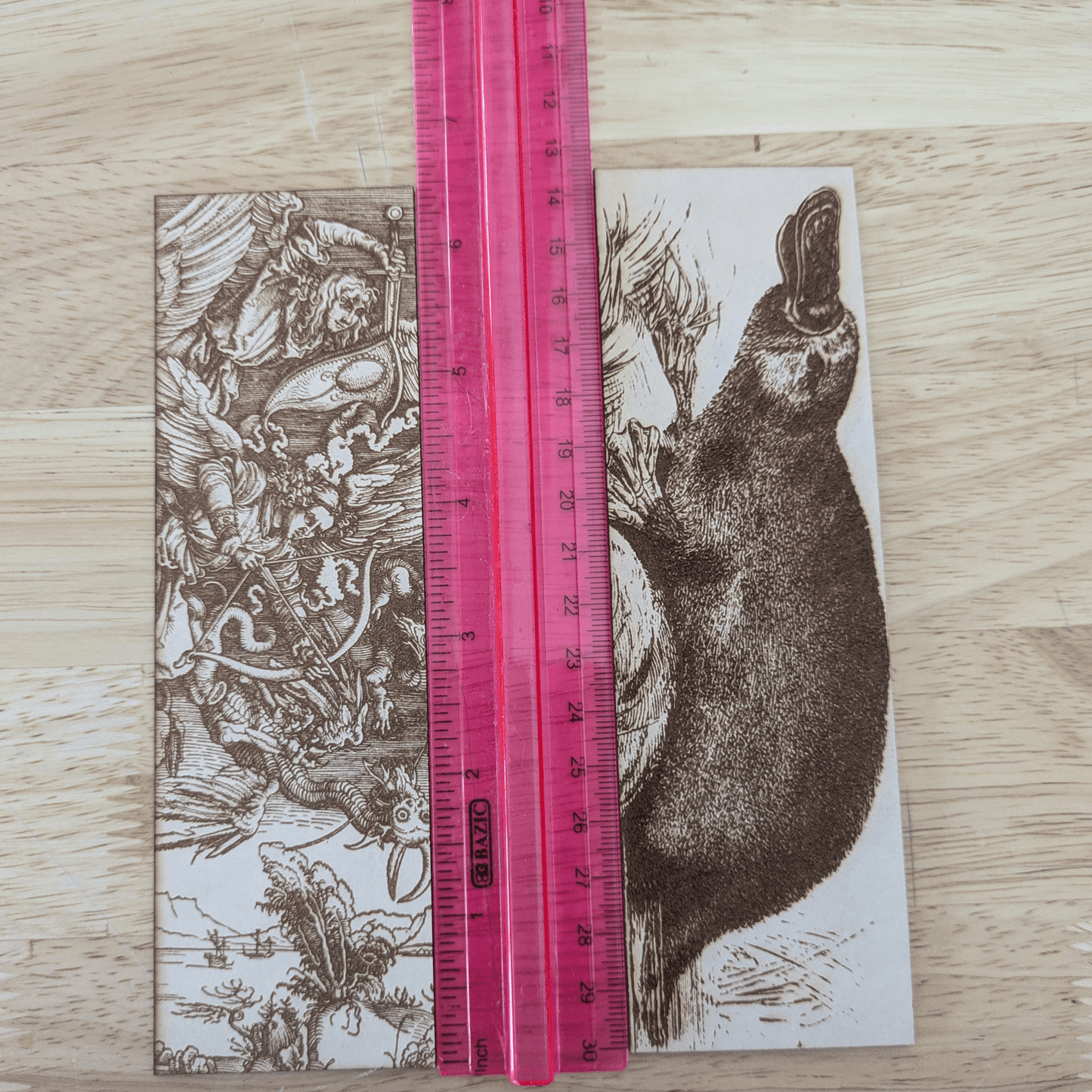 A photograph of the demons vs angels bookmark and the platypus bookmark next to a ruler for scale. Angels battling Demons Bookmarks Raven King Crafts