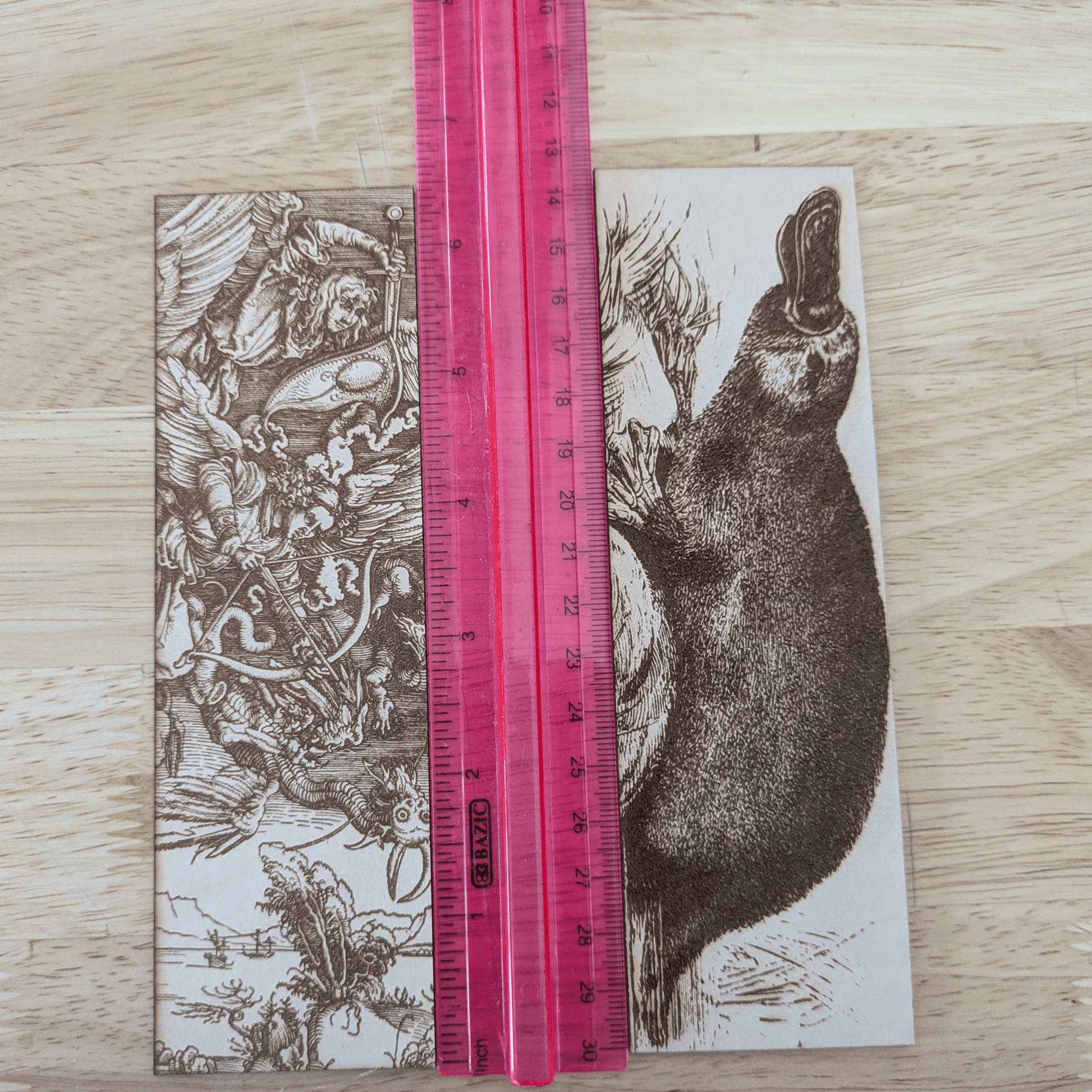 A photograph of the demons vs angels bookmark and the platypus bookmark next to a ruler for scale. Angels battling Demons Bookmarks Raven King Crafts