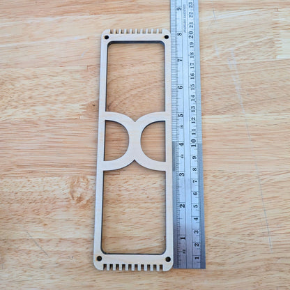 The wooden frame loom designed for bookmark weaving next to a ruler for scale. 