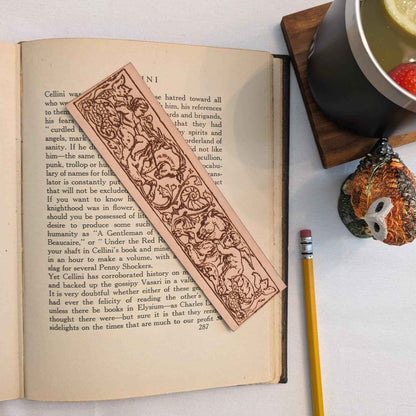 A leather bookmark engraved with the antique art of a cherub angels riding a hippocampus. Cherubs Riding Hippocampus Bookmark - Leather Bookmarks Raven King Crafts