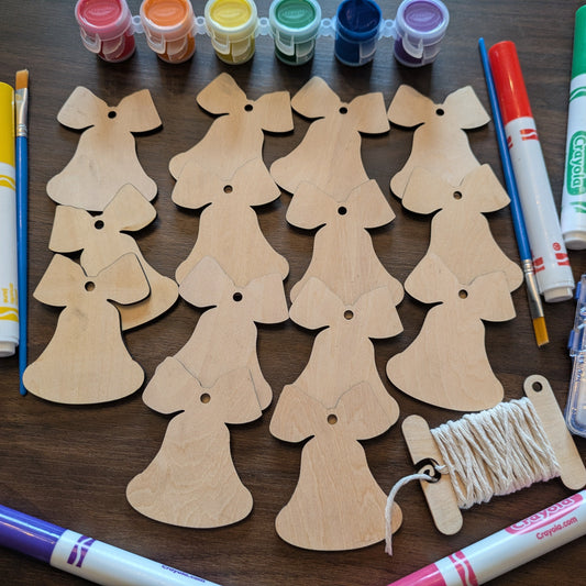 A photograph of the Christmas Bell ornament blanks from above. Around the wooden ornaments are some of the marker and paint options. Christmas Bell Ornament Blanks - 14 Pack Ornament Raven King Crafts