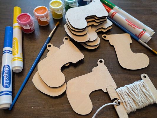 A photograph of the wooden Christmas stocking ornament blanks next to some of the paint and marker options. Christmas Stocking Ornament Blanks - 12 Ornament Raven King Crafts