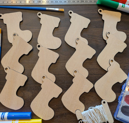 A photograph of the wooden Christmas stocking ornament blanks next to markers and paint options.