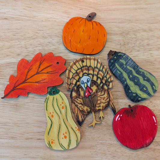 A photograph of some of the Thanksgiving ornaments colored, including a leaf, pumpkin, gourd, apple and turkey.