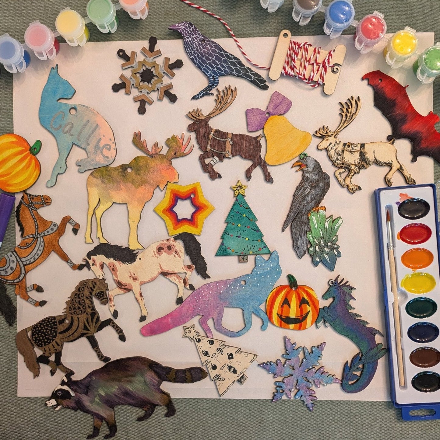 A photograph of different ornaments and examples of them colored. DIY Dog Ornament Kit - 2 Set Options: Frenchie, shiba, corgi, poodle, pitbul, newfie, setter, terrier, collie, boxer and more! Art & Craft Kits Raven King Crafts
