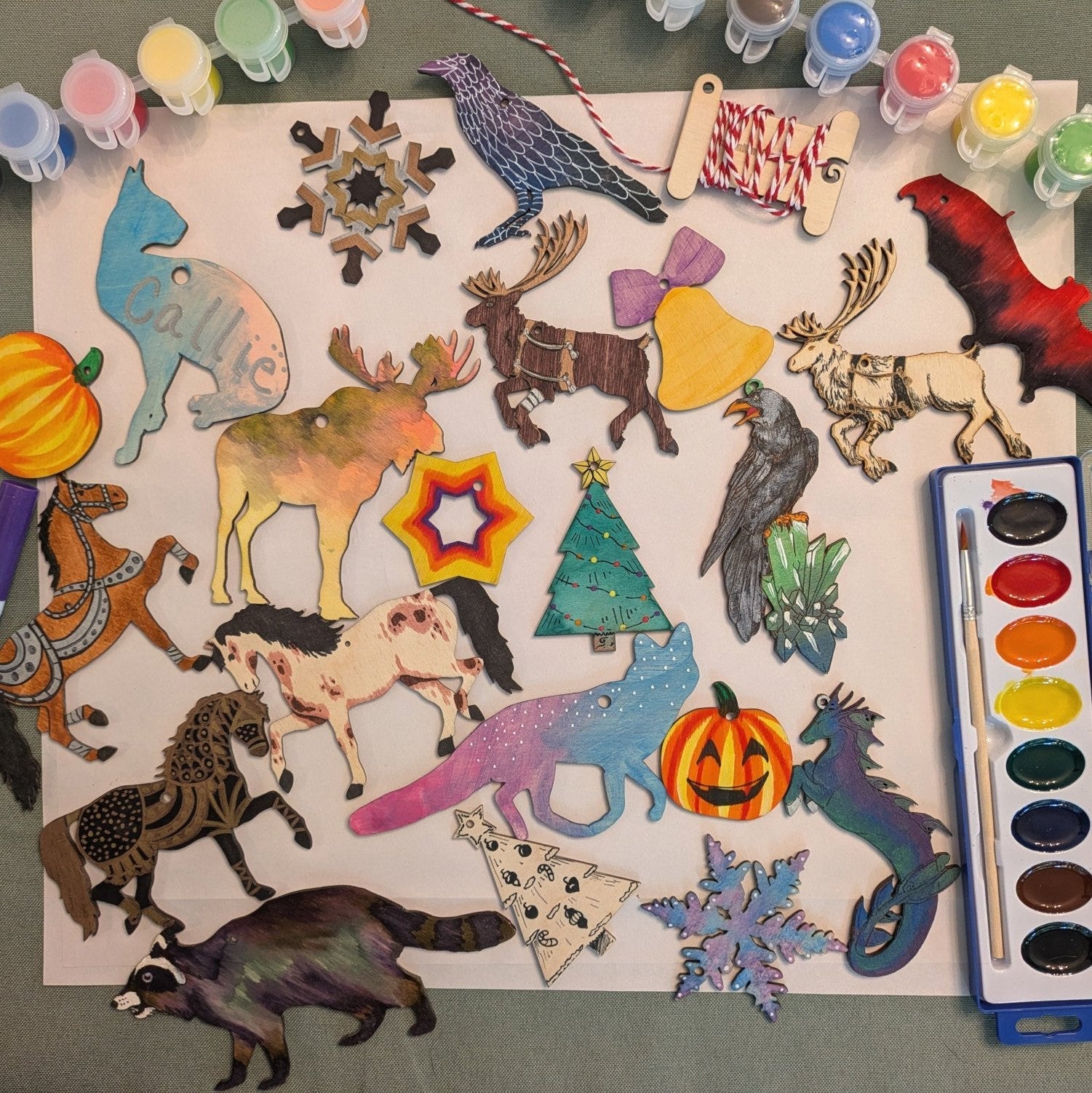 A photograph of different ornaments and examples of them colored. DIY Dog Ornament Kit - 2 Set Options: Frenchie, shiba, corgi, poodle, pitbul, newfie, setter, terrier, collie, boxer and more! Art & Craft Kits Raven King Crafts