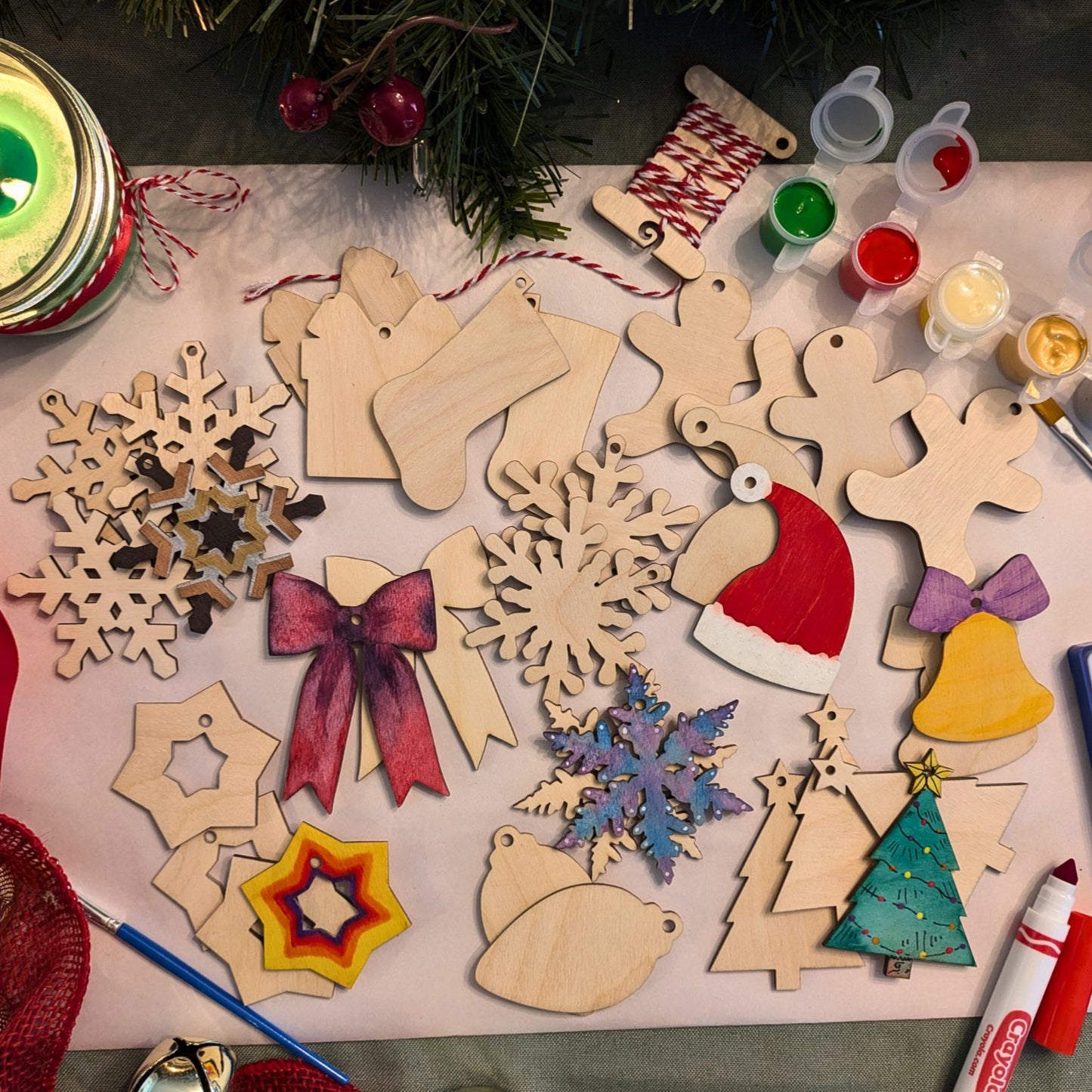 Photograph of both sets of Christmas ornament blanks, with some painted or colored as examples. Photograph includes snowflake ornaments, stocking ornaments, present ornaments, gingerbread men ornaments, bell ornaments, ribbon ornaments, star ornaments, bulb ornaments, tree ornaments and Santa hat ornaments.