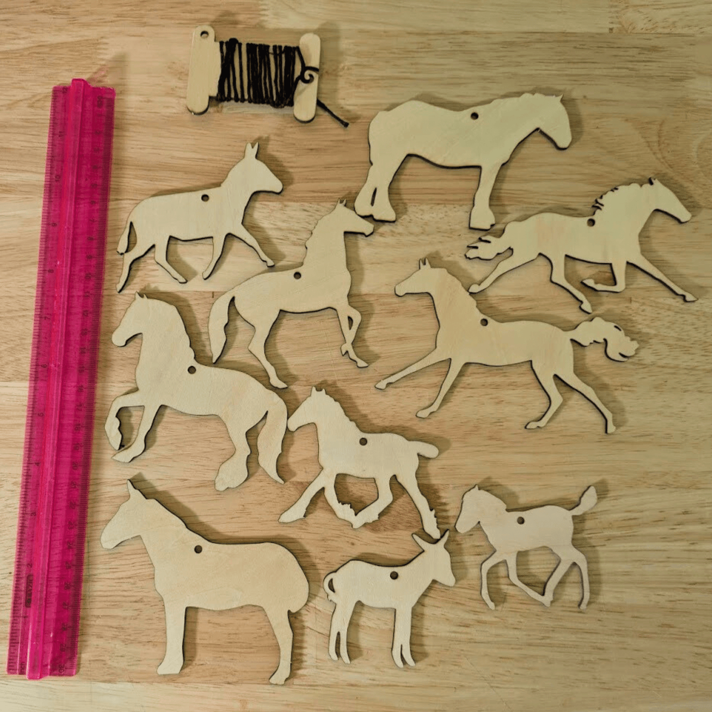 Set 2 of the wooden horse ornament sets next to a ruler to show scale. The set has 10 different horse, mule and donkey cutouts. DIY Wooden Horse Ornament Kit - 10 Unique Horse Shapes per Set - 20 total! Art & Crafting Materials Raven King Crafts
