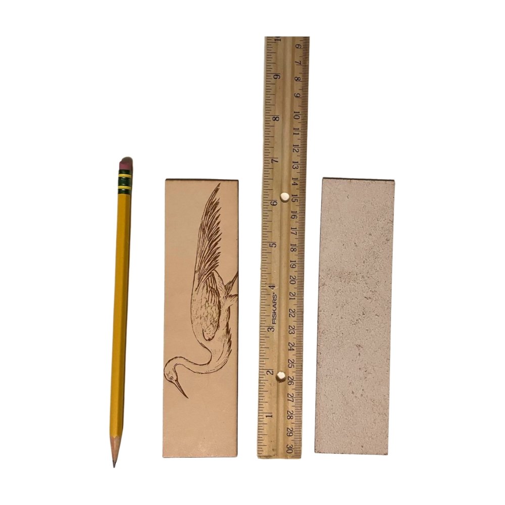 A photograph of the front of the leather bookmark and the back. The bookmarks are next to a ruler and a pencil for scale. Back photo shows the bookmark back is unfinished.