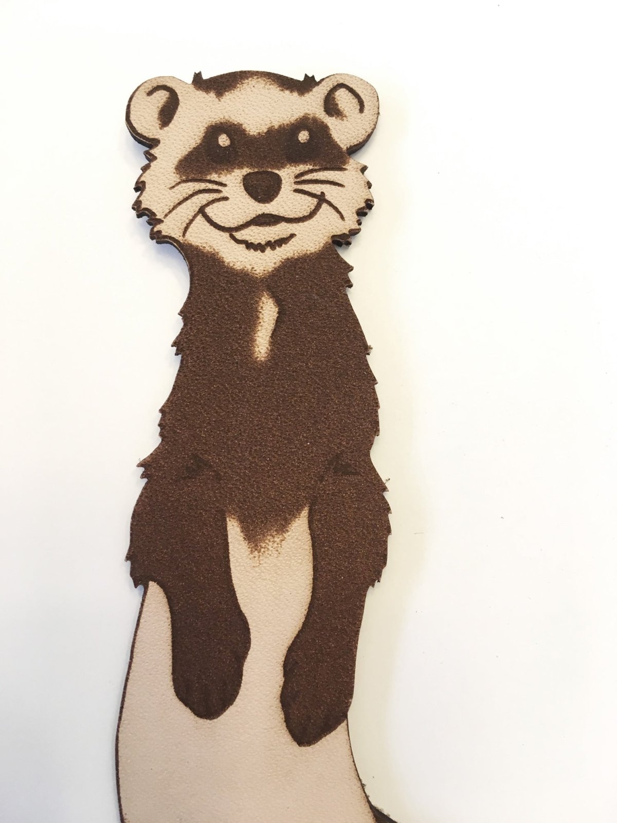 a ferret engraved on a leather bookmark