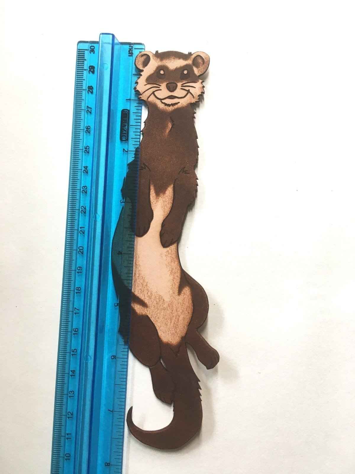 The leather weasel bookmark next to a ruler for scale. Ferret Bookmark Made From Hand Selected Leather Bookmarks Raven King Crafts