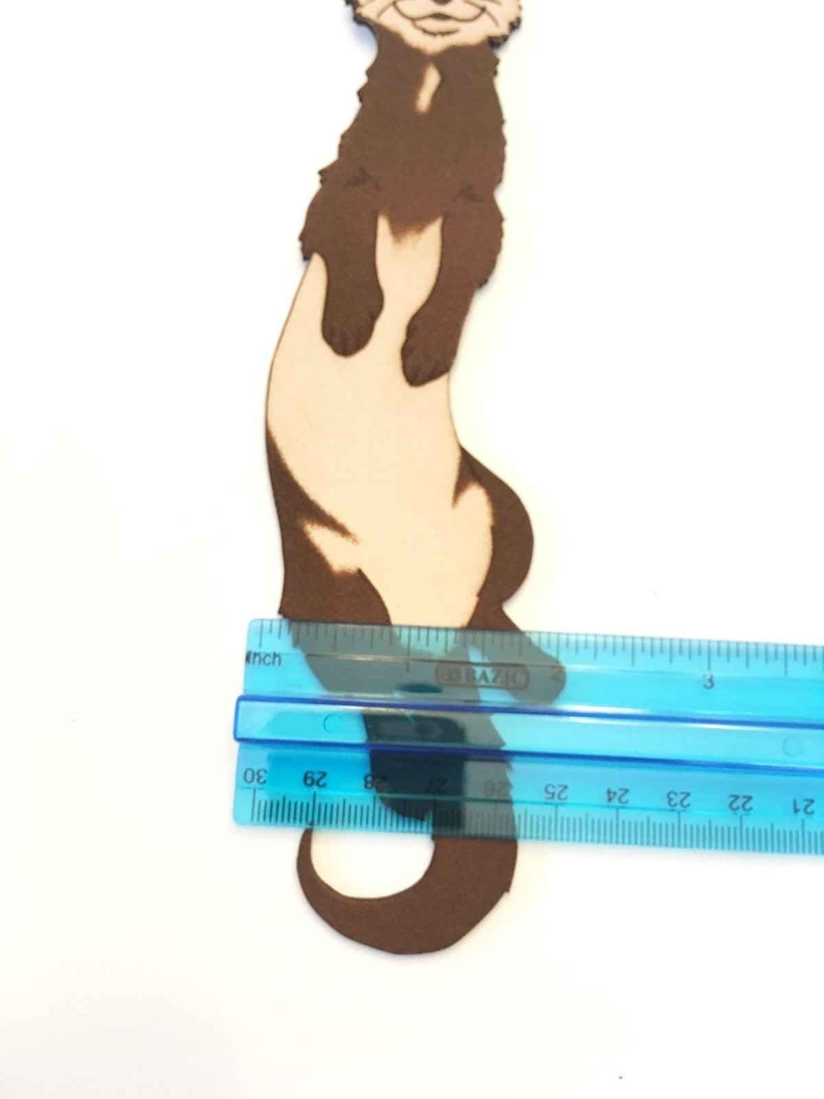 The leather ferret bookmark next to a rulter for scale. Ferret Bookmark Made From Hand Selected Leather Bookmarks Raven King Crafts