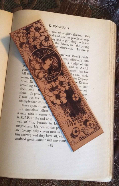 A leather bookmar engraved with the art of a woman and flowers. Flower Maiden Bookmark Bookmarks Raven King Crafts