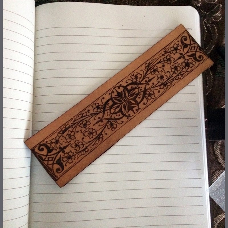 an ornate leather bookmark resting on a book