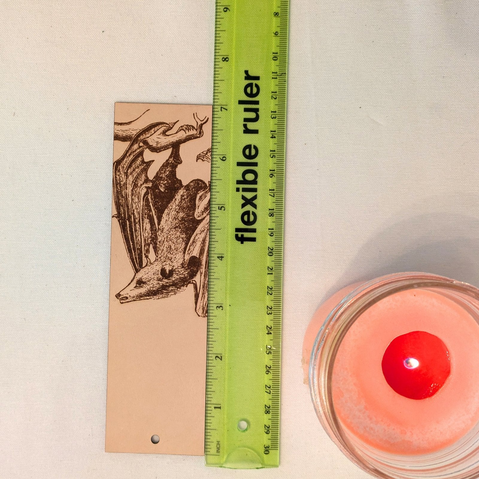 Leather bat bookmark next to a ruler for scale. Flying Fox Bat Bookmark - Leather Historical Bookmarks Raven King Crafts