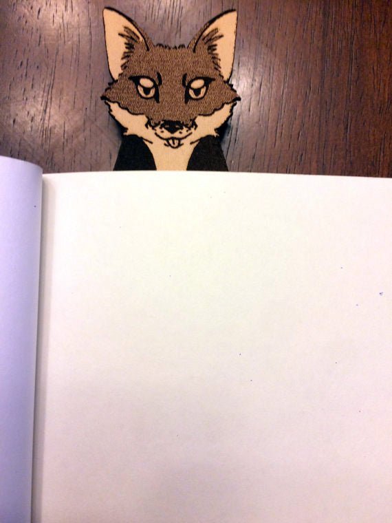 a fox head sticking out from a sketch book