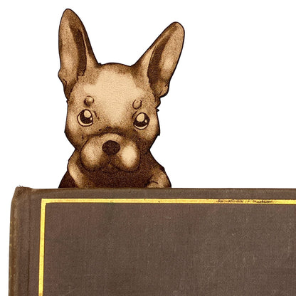 The leather French Bulldog puppy head popping out of a book.