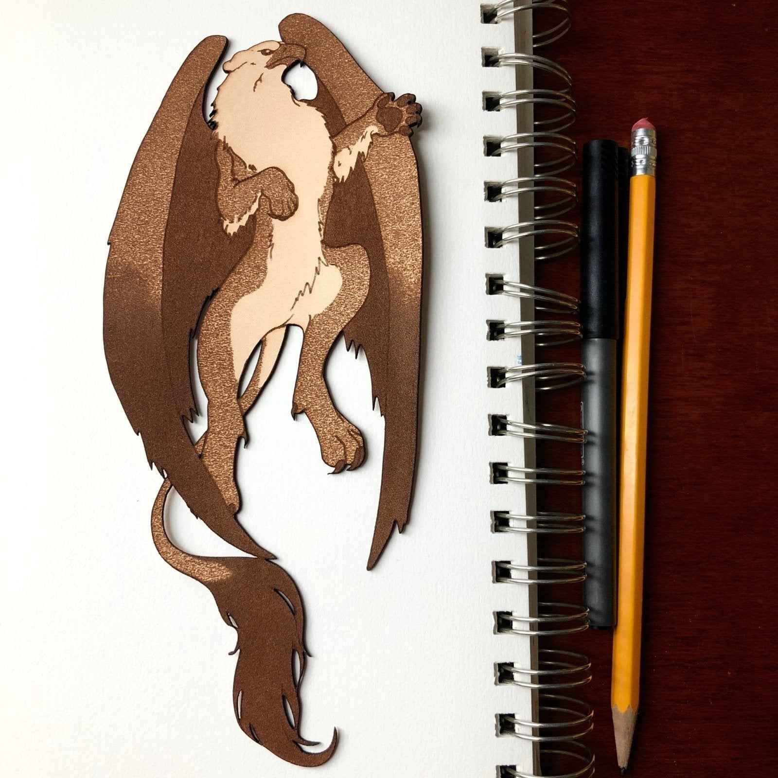 A leather bookmark shaped like the mythical beast the griffin. Griffin Bookmark - Leather | Wonderful Fantasy Beast Gift Bookmarks Raven King Crafts