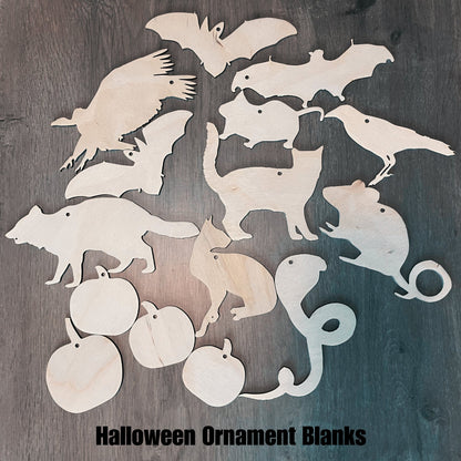 A photograph of the Halloween themed ornament blanks. There are bats, a mouse, a rat, a crow, cats, a cobra , vulture, raccoon and pumpkins.