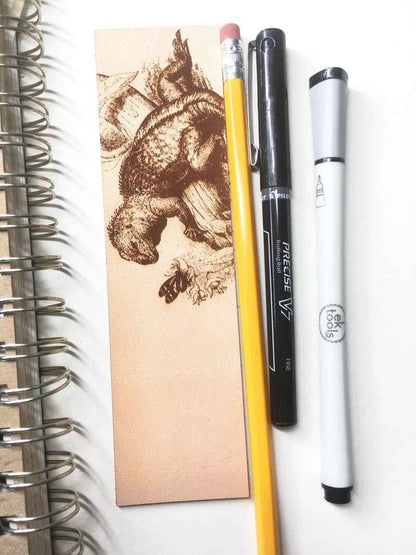 A leather bookmark engraved with the antique art of a iquana. Historical Leather Iguana Bookmark Bookmarks Raven King Crafts