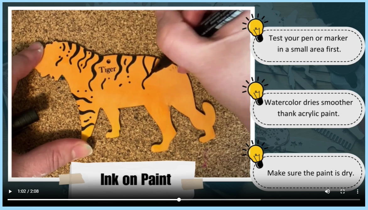 A screen shot of the video of a tiger ornament being inked after it was colored with a marker.