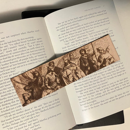 A leather bookmark with the art of a king and his knights on horse back. It might be art of King Aurther Pendragon..